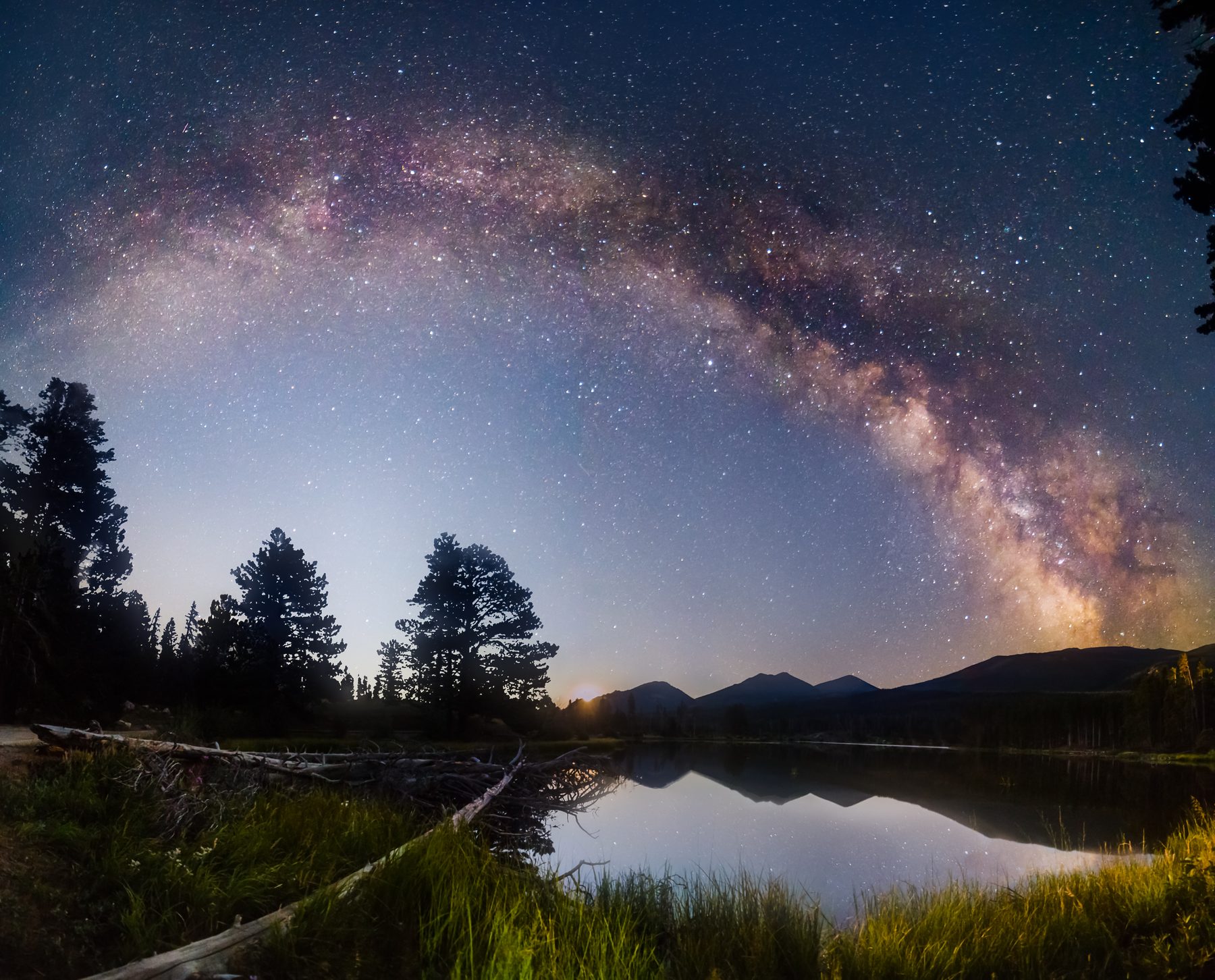 The full arch of the Milky Way spanning a lake and reflecting in the water