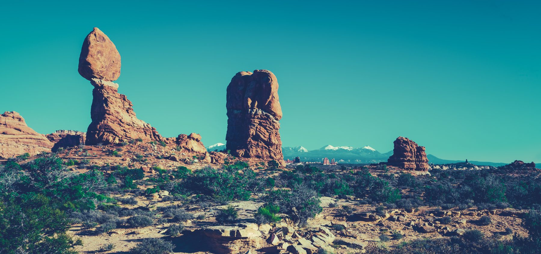 Balanced Rock and its neighbouring tower against a vivid turquoise sky