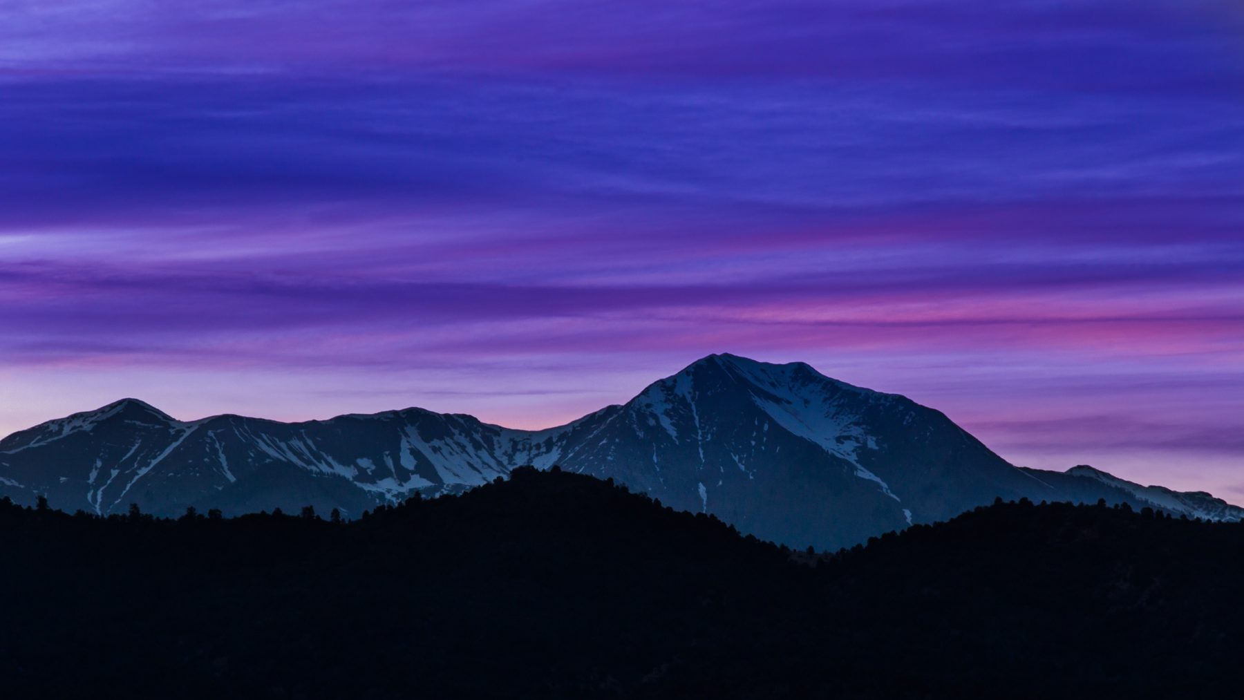 The La Sal Mountains in silhouette beneath a deep purple and pink twilight